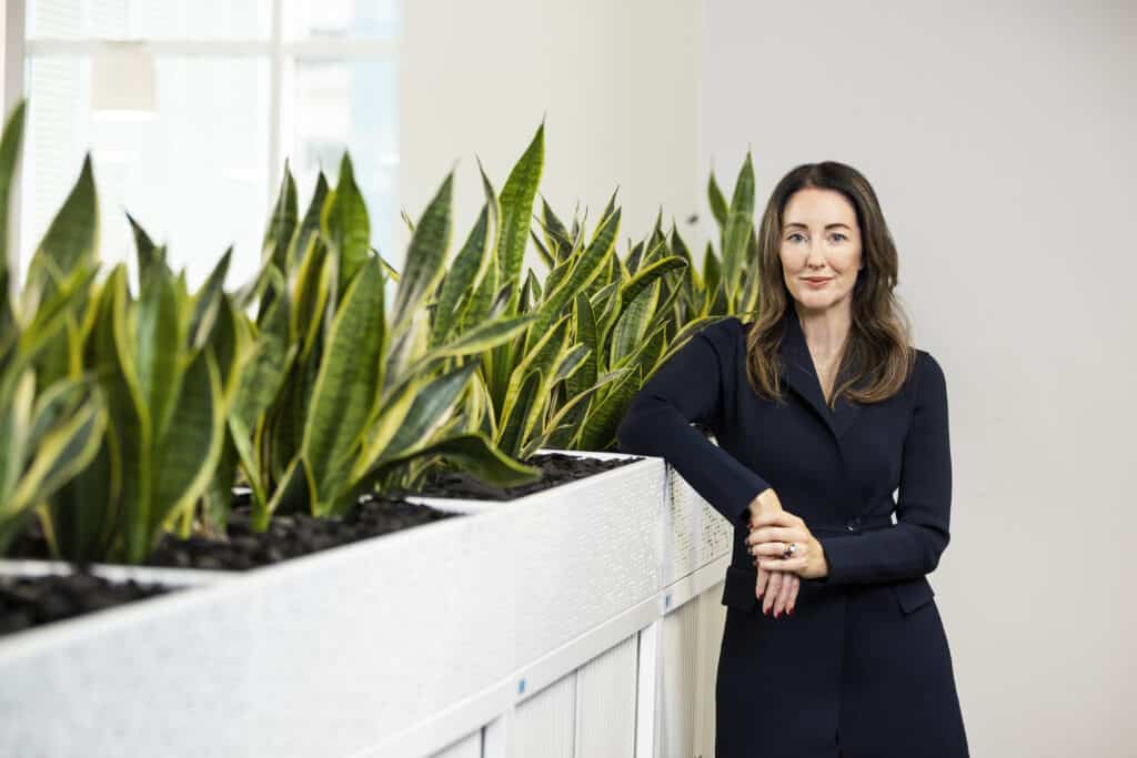 Mary-Delahunty-ASFA-CEO-standing-in-th-ASFA-offices-beside-plants